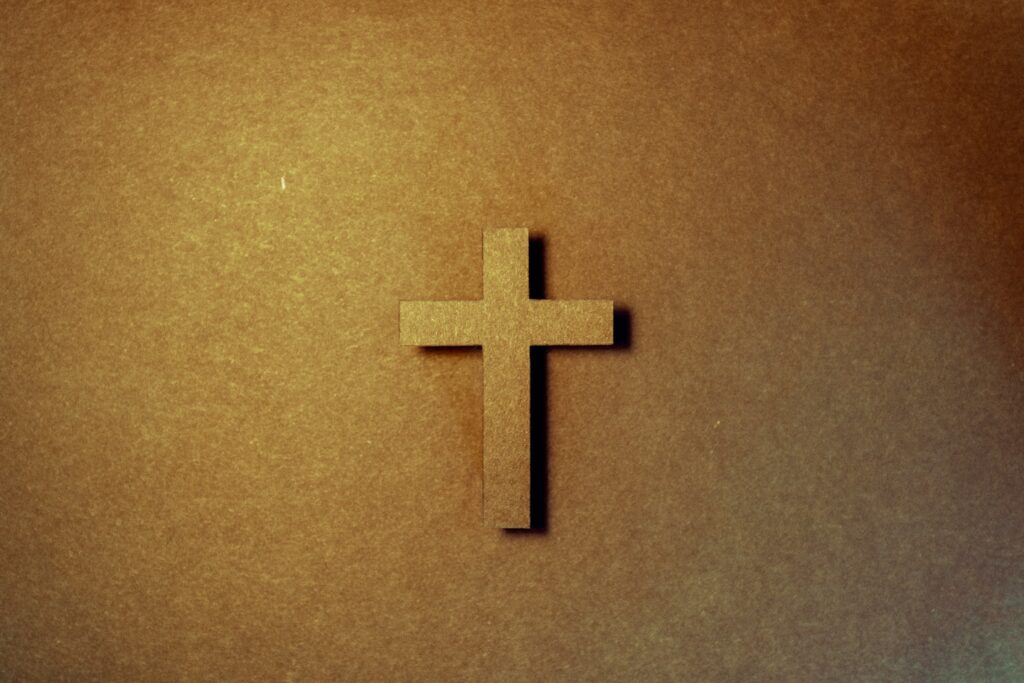 Paper cut cross laying on a paper background