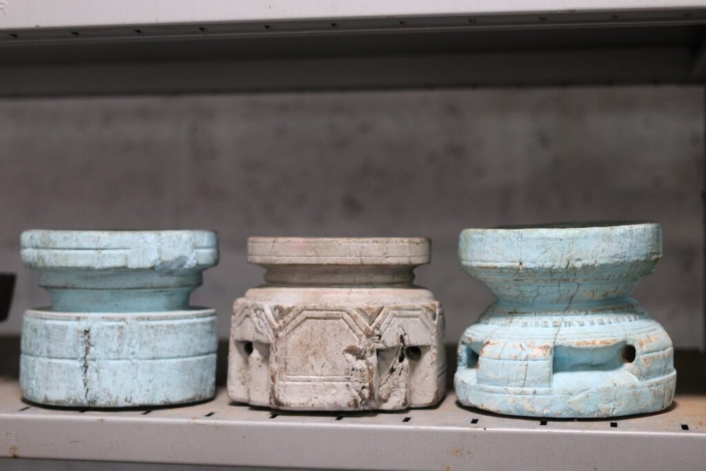 Three carved wooden objects on a shelf
